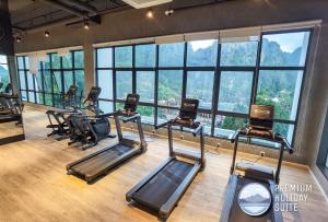 淡文Premium Holiday Suite beside Lost World Tambun的一间健身房,里面设有一排跑步机和窗户