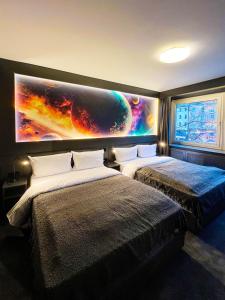 汉堡Sleephotels Cosmos的一张位于墙上的大画的房间里,设有两张床