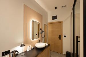 贝尔格莱德Hop Inn Rooms & Suites的一间带水槽和镜子的浴室