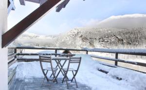 里雾诗Les Grand Balcon - 2ch - 2 balcons - Randonnée - Escalade - Lac des Chavants的雪覆盖的山景阳台上的桌椅