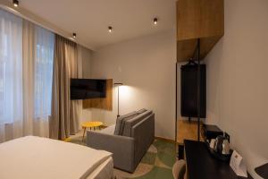 贝尔格莱德Hop Inn Rooms & Suites的酒店的客房 - 带一张床、椅子和电视