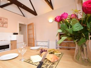 海布里奇1 bed in Burnham-on-Sea ALPAD的一张桌子,上面有玫瑰花瓶和一盘食物