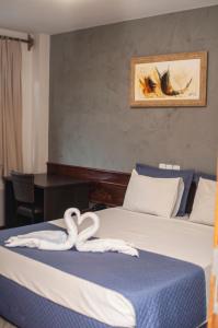 伊瓜苏Hotel Portinari Ponte da Amizade的酒店客房,配有两张带毛巾的床