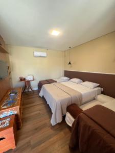 阿帕雷西达Rogai Hotel Pousada的一间设有两张床和一张桌子的房间