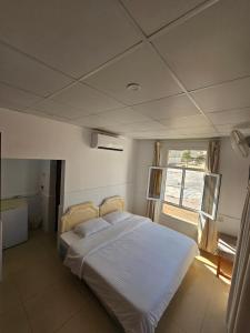 苏尔Wadi ashab chalets شاليهات وادي الشاب的卧室配有白色的床和窗户。