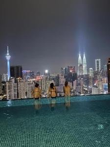 吉隆坡Lucentia Residence by Moonlight Park的一群人站在泳池边,俯瞰城市