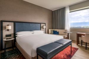 日内瓦Geneva Marriott Hotel的一间卧室设有一张大床和一个大窗户
