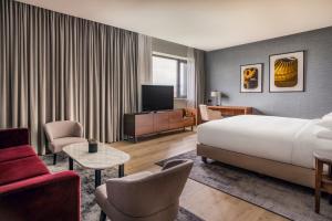日内瓦Geneva Marriott Hotel的一间酒店客房,配有一张床和一台电视