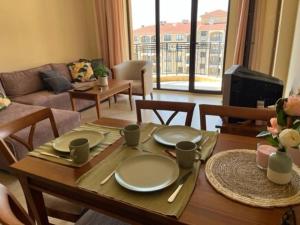 金沙Apartment Golden Sands and Black Sea, Varna的客厅配有带盘子的桌子