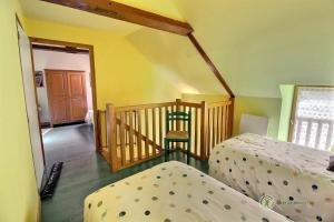 Saint-GildasTournesol的客房设有两张床和一个带椅子的楼梯。