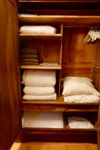 圣吉扬莱代塞尔CHARMANTE MAISON A SAINT GUILHEM LE DESERT的配有白色毛巾和枕头的衣柜