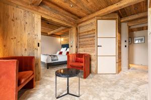 谷雪维尔勒查比措酒店的一间设有木墙的房间和一间配有床的卧室
