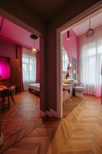 福贾Momento Soggiorno di Charme的浴室设有粉红色的墙壁、水槽和卫生间