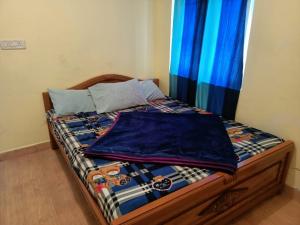 乌提Wander Valley的一张带蓝色床单和枕头的床