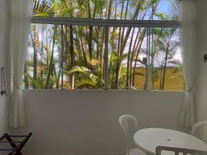 乌巴图巴卡里曼宾馆的窗户配有桌椅和棕榈树
