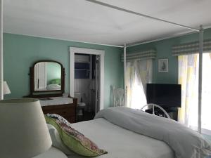 Jaffrey莫纳德诺克旅馆（Monadnock Inn）的一间卧室配有一张床和镜子