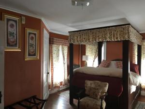 Jaffrey莫纳德诺克旅馆（Monadnock Inn）的一间卧室配有一张大床和一把椅子