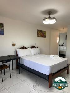 哈拉瓦科阿Jade Mountain Suites, Jarabacoa的一间卧室配有一张大床和一张桌子