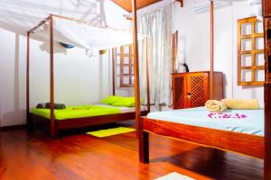 贝岛Appartement vue sur mer chez VILLA AMNESYA的一间卧室配有两张双层床,铺有绿色床单。