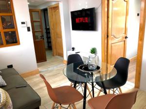 昆卡Family Apartment centro ciudad + Netflix的客厅配有玻璃桌和椅子