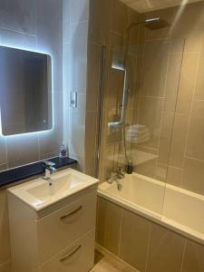 利物浦Luxurious 1 Bed - CITY VIEWS的浴室配有水槽、淋浴和浴缸。