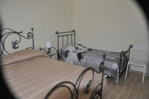 蒙特科尔维诺-罗韦拉La Vecchia Lanterna的一间卧室配有两张单人床和一把椅子