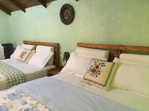 RangalaThe Vintage Villa - Knuckles的一间卧室设有两张床,墙上挂着一个时钟。