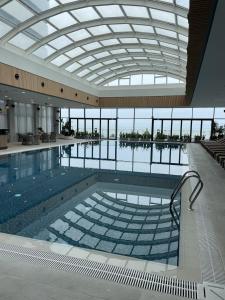 巴统Poseidon Apartments Batumi的一座带玻璃天花板的大型游泳池