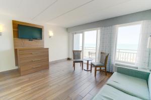 弗吉尼亚海滩弗吉尼亚海滩海滨马尔杰克套房酒店的客厅配有电视和桌椅