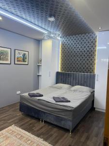 佐洛埃格塞格Hotello Apartmanház és Panzió的一间卧室设有一张蓝色天花板的大床