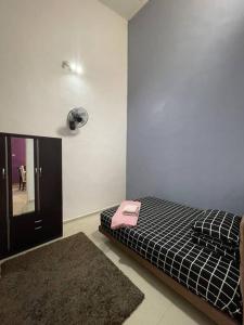 马六甲Homestay ShimahJay Telok Mas Melaka的一间卧室配有一张床,上面装有粉红色的电话