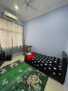 马六甲Homestay ShimahJay Telok Mas Melaka的一间卧室,床上有花纹
