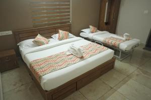 瓦亚纳德Luxe Hotel - Rooms & Villas Wayanad的两张位于酒店客房的床,配有毛巾