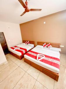 瓦亚纳德Luxe Hotel - Rooms & Villas Wayanad的两张睡床彼此相邻,位于一个房间里
