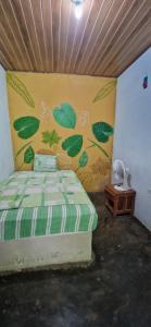 RusiaFinca Mamacita的卧室配有一张墙壁上涂有绿叶的床。