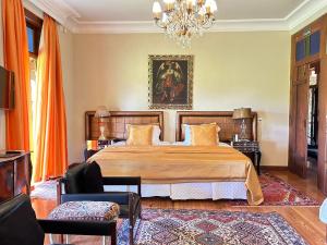 布罗塔斯Villa Maria Pousada de Charme的一间卧室配有一张大床和一个吊灯。