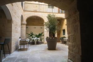 比尔古IBB Hotel Palazzo Bettina Malta的庭院,带桌子和盆栽植物