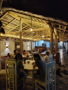 韦利格默The Lost Hostels, Weligama Beach - Sri Lanka的一群坐在餐厅桌子上的人