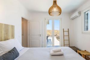 Merchia BeachSea Rock & Sky Private Mykonos Residence的卧室配有白色的床和窗户。