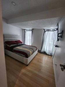 蒂明斯Foresight Chalet Laidlaw的一间卧室设有一张床和两个窗户。