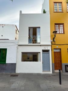 拉克鲁斯Fantástica vivienda situada el el corazón del Puerto de la Cruz的白色的建筑,设有两扇门和一扇窗户