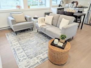 温哥华Centrally located, modern, 2 bedroom home的客厅配有沙发、两把椅子和一张桌子