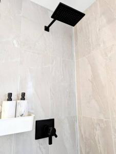 温哥华Centrally located, modern, 2 bedroom home的浴室设有黑色灯淋浴