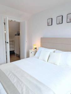 温哥华Centrally located, modern, 2 bedroom home的卧室内的白色床和白色枕头