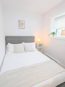 温哥华Centrally located, modern, 2 bedroom home的白色卧室内的一张白色床,设有窗户