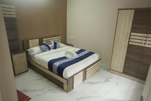 瓦亚纳德Luxe Hotel - Rooms & Villas Wayanad的一间卧室配有蓝色和白色床单