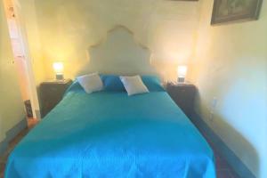 SeanoCasa tranquilla colonica toscana vicino a Firenze的一间卧室配有蓝色的床和两盏灯