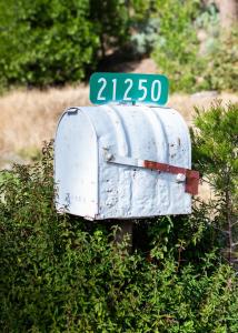 格罗夫兰Inn at Sugar Pine Ranch的灌木丛上带有街道标志的邮箱