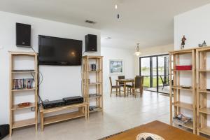 夏洛特港湖畔阿迪度假屋的客厅设有壁挂式平面电视。