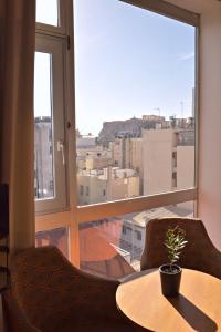 雅典阿瑞图萨酒店的客房设有桌子和大窗户。